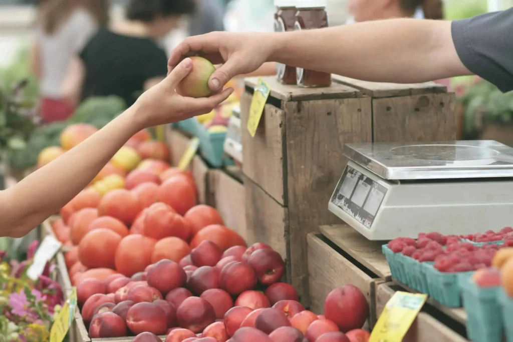 A person buying an apple at a market