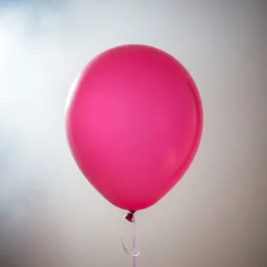 Balão redondo na cor rosa-pink. Fundo cinza.