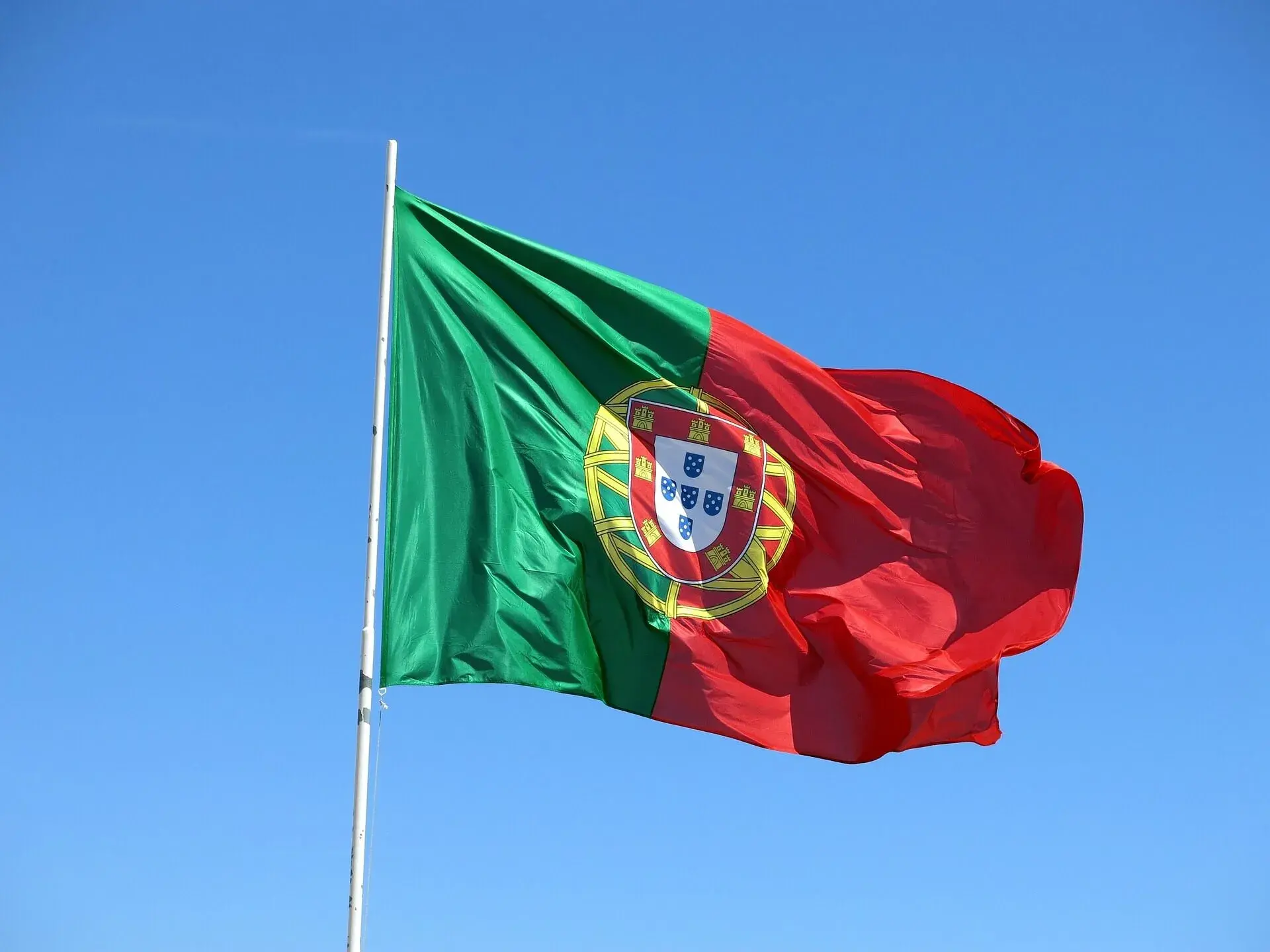 The flag of Portugal on a flagpole, blowing in the wind