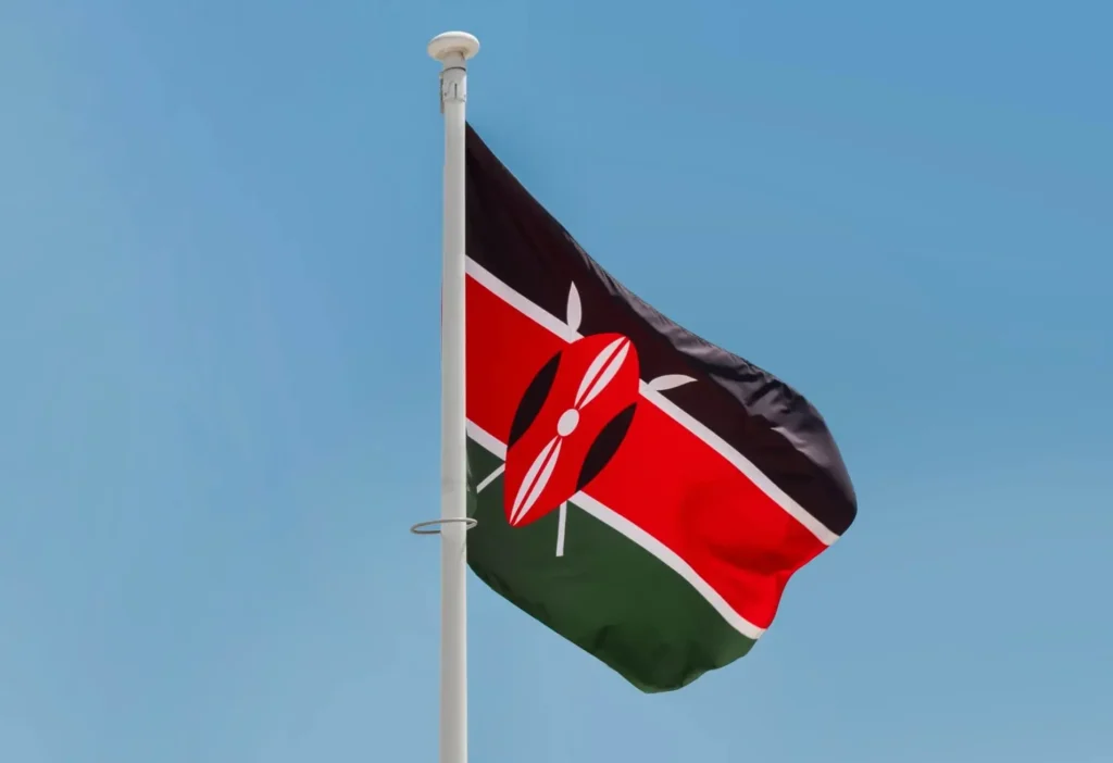 The flag of Kenya on a flagpole against a blue sky
