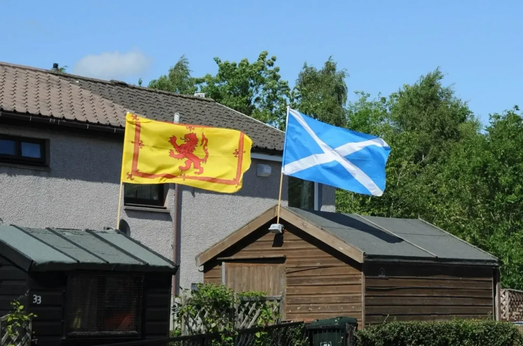 The Lion Rampart, or the Royal Banner of the Royal Arms of Scotland, a yellow flag with a red lion